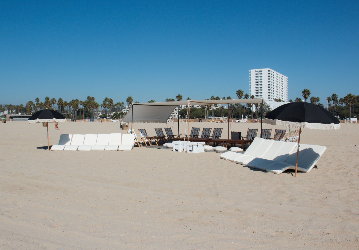 Large beach lounge rental with beach lounges and beach umbrellas in Santa Monica on the beach