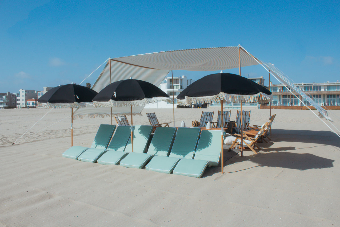 Beach cabana rental from The Beach Oasis with beach lounges, beach umbrellas, and beach chairs on a Los Angeles beach