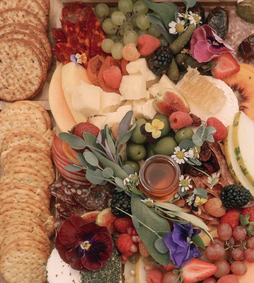 Luxury Charcuterie Board with Meat, Cheese, Fruit, Honey and Edible Flowers at a Beach Picnic in Los Angeles 