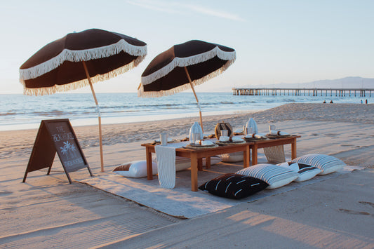 Beach picnic Los Angeles for your LA beach party with place settings, beach umbrellas, and seating
